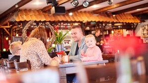 Ein Restaurantinneres mit Holzbalken, einer Bar und einer Sitzgelegenheit.