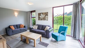 Ein modernes Wohnzimmer mit zwei Sofas, einem Couchtisch und einem blauen Sessel.
