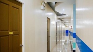 Un couloir avec une porte en bois, un interrupteur et un mur d’accent bleu.