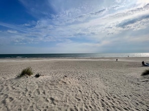 A wide sandy beach with gentle waves and a clear sky. - 4 Star Holiday Home in Blavand (Blavand)