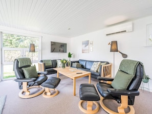 A modern living room with a sofa, chairs, a coffee table, and a TV. - 4 Star Holiday Home in Blavand (Blavand)