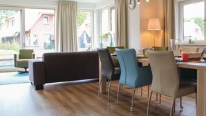 A modern dining area with a sofa, chairs, and a table.