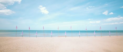 On the beach, white sand, beach umbrellas, beach towels