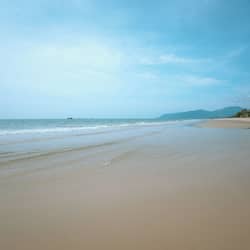 En la playa, arena blanca, sombrillas, toallas de playa