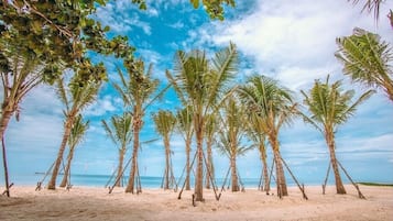 On the beach, white sand, beach umbrellas, beach towels