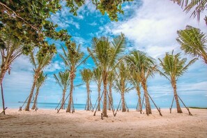On the beach, white sand, beach umbrellas, beach towels