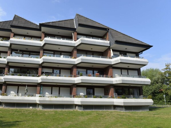 A multi-story building with balconies, large windows, and a flat roof. - Apartment Albatros 14 (Butjadingen)