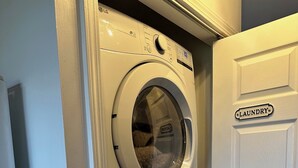 A laundry room with a white door labeled "LAUNDRY" and a stacked washer and dryer.