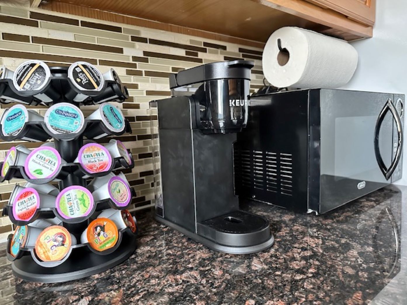 A coffee machine with multiple coffee pods and a paper towel roll.