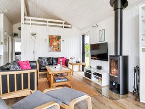 A modern living room with a fireplace, a sofa set, a coffee table, and a flat-screen TV. - 5 Star Holiday Home in Humble (Sydlangeland)