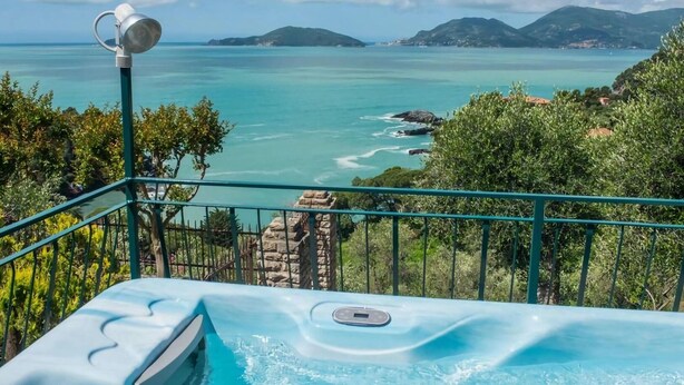Ein Whirlpool mit Blick auf das Meer und die Berge.