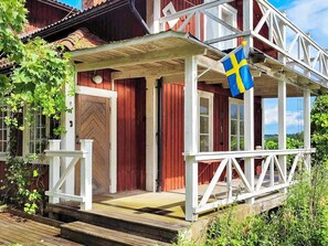 A wooden house with a porch, a flag, and a door. - 7 Person Holiday Home in Nykvarn-by Traum (Nykvarn)