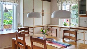 Una cucina moderna con mobili in legno, un'isola centrale e luci a sospensione.