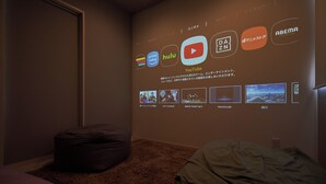 A room with a projection of streaming services logos on the wall, a bean bag, and a bed. - Mt Fuji Resort Club -Relax- (Fujikawaguchiko)