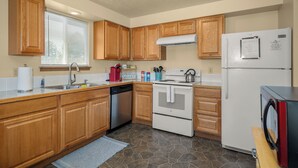 A kitchen with wooden cabinets, a dishwasher, a stove, a refrigerator, and a microwave. - Beautiful 2BR APT 2 ⭑ Netflix & Keurig ⭑ Full Kitchen ⭑ WiFi ⭑ AC (Spokane Valley)
