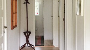 A hallway with a wooden floor, a coat rack, and a door leading to another room. - 4 Star Holiday Home in Gotlands Tofta (Gotlands Tofta)