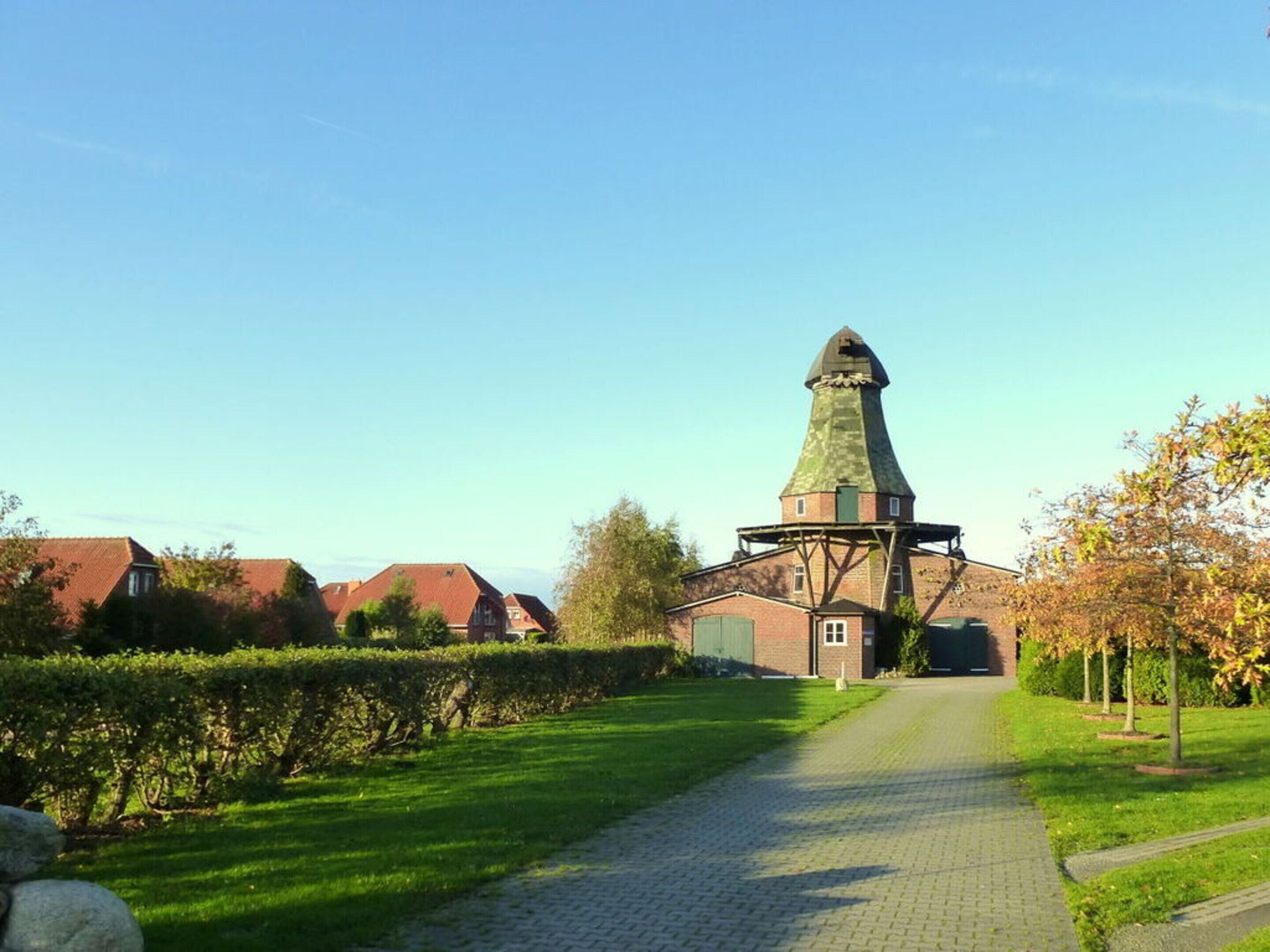 A pathway leading to a building with a distinctive tower.