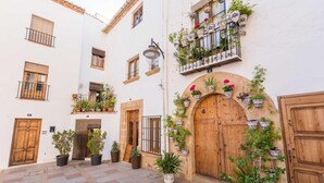 A courtyard with a wooden door, potted plants, and a tiled floor. - Villa La Seldeta by Solidays - Moraira, Costa Blanca (Moraira)