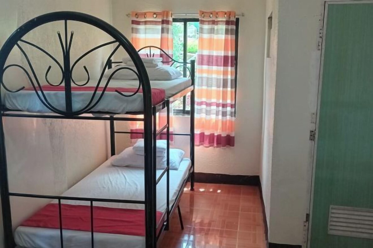 A bunk bed room with a window and curtains.