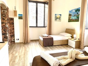 A bedroom with a wooden bed, a nightstand, a window with curtains, and artwork on the walls. - Casa Silos, a due Passi dal Centro Storico e dal Mare (Catania)
