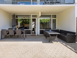 Un patio al aire libre con mesa y sillas, un sofá y una zona de estar cubierta.