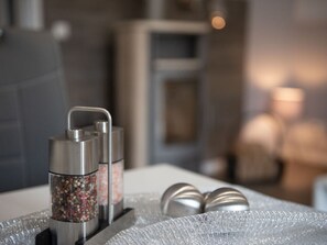 A bathroom with a modern design, featuring a metallic showerhead and a glass container with various items.