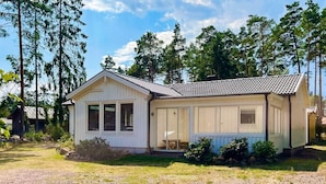 A small, single-story cabin with a gabled roof, a front porch, and a number '5' on the door. - 4 Star Holiday Home in Monsteras (Monsteras)
