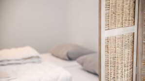 A bed with white bedding and a grey pillow. - Luxury new Apartment on Ameland (Buren)