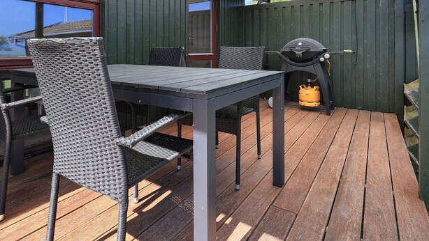 An outdoor patio with a table and chairs, a grill, and a gas cylinder. - 4 Star Holiday Home in Praesto (Praesto)