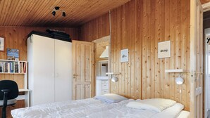 A bedroom with a large bed, a desk, and a wardrobe. - 4 Star Holiday Home in Praesto (Praesto)