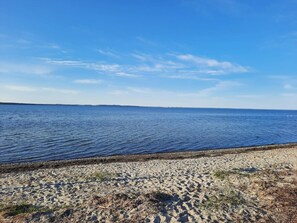 A beach with clear blue water and a sandy shore.