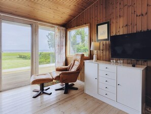 A room with a leather chair, a TV, and a cabinet.