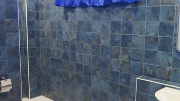 A bathroom with blue tiles, a white sink, and a toilet.