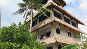 Un edificio de varios pisos con fachada de piedra y secciones de techo de paja.