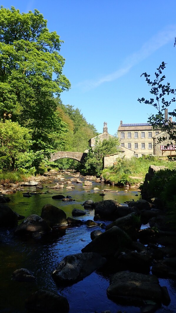 A stone bridge over a river with a building in the background. - Apartment overlooking the river in the heart of Hebden Bridge - Pet friendly! (Hebden Bridge)