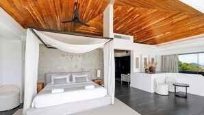 A modern bedroom with a large bed, a ceiling fan, and a view of the outdoors. - Serene Escape Villa in Chaweng - KBR20 (Koh Samui)