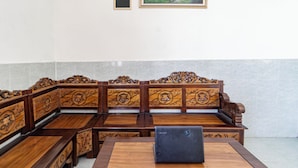 A traditional wooden bench seating area with a laptop on a table.