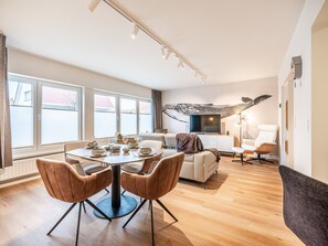 Enjoy meals at the central dining table surrounded by comfortable seating and a flat-screen TV.