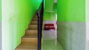 Eine Treppe mit grünen Wänden und einem hölzernen Geländer.