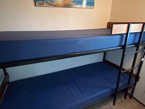 Uma cama beliche com colchão azul e estrutura de metal.