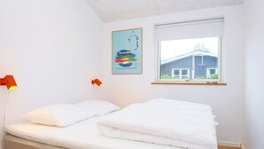 Una stanza con un letto, una finestra e un lampadario a parete.