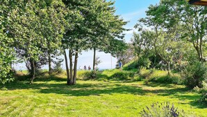 A grassy outdoor area with trees and a stone bench. - 5 Star Holiday Home in Sydals (Sydals)