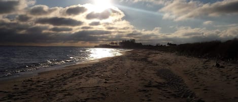 A beach with footprints and a clear sky.