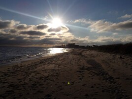 A beach with footprints and a clear sky.