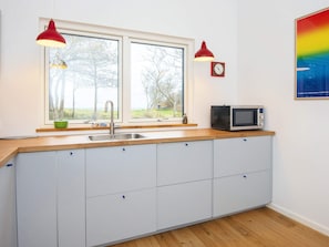 A kitchen with a double sink, wooden countertop, and a microwave. - 5 Star Holiday Home in Sydals (Sydals)