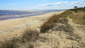 A beach with a clear sky and distant mountains.