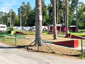 A fenced outdoor area with picnic tables and a red building. - 2 Person Holiday Home in Bromolla (Bromolla)