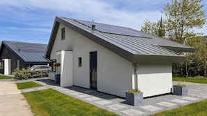 A modern house with a sloped roof, solar panels, and a well-maintained lawn. - Eco-friendly Villa With Terrace and Garden (Dirkshorn)