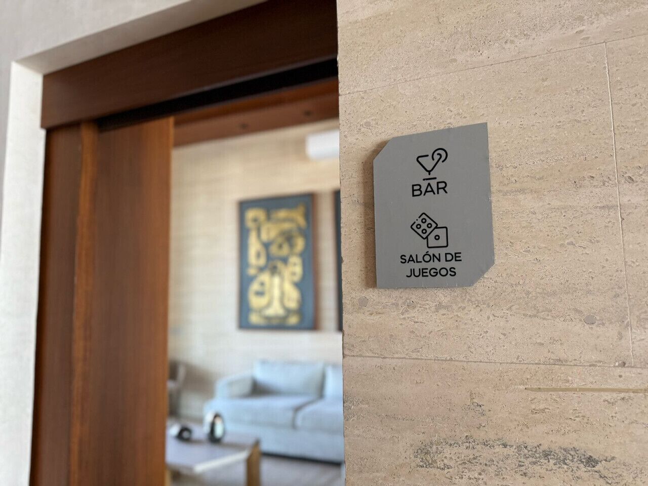 A sign indicating a bar and a room with a large abstract painting.