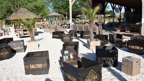 A beachside restaurant with wooden crates labeled 'SALITOS' and outdoor seating under a wooden canopy. - Holiday Home Maja am See (Aurich)